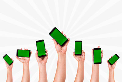 Close-up of hand holding paper over white background