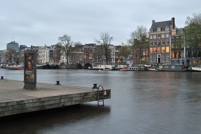 View of boats in harbor against cloudy sky