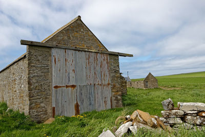 Old building on field against sky