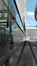 Walkway in city against sky