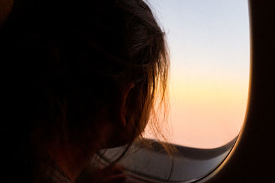 Little girl looking out airplane window during flight