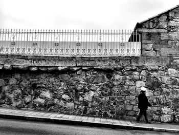 Full length of woman standing in front of wall