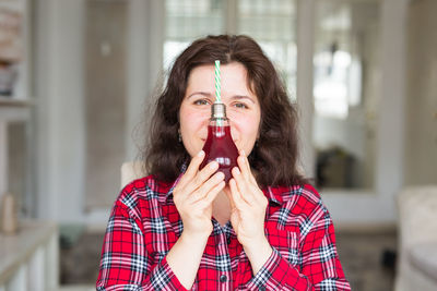 Portrait of young woman drinking glasses