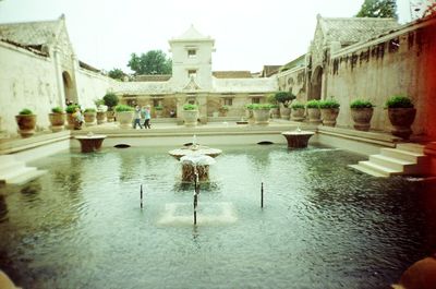 Fountain in city against clear sky