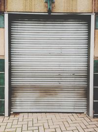 Closed shutter of store at sidewalk