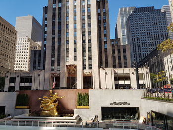 Low angle view of statue against buildings in city