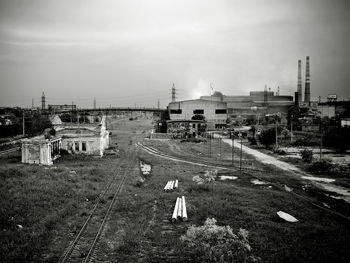 High angle view of railroad tracks by buildings in city against sky