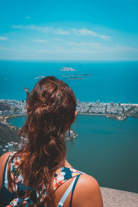 Rear view of woman standing against sea and sky