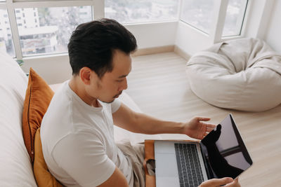 High angle view of man using laptop at home