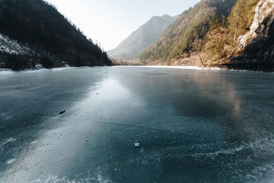 Scenic view of lake by mountains during winter