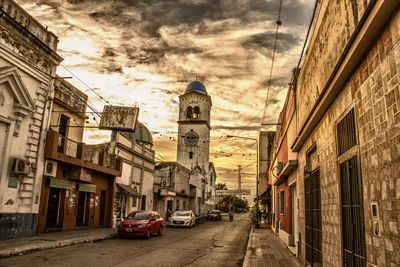 View of city street against cloudy sky