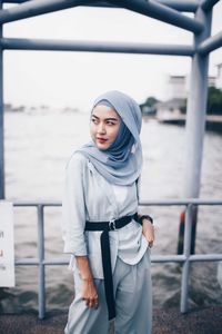 Full length of woman standing against railing
