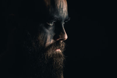 Portrait of man against black background