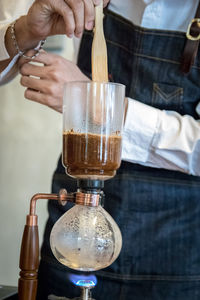 Close-up of hand pouring drink in glass