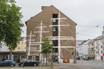 Cars on road by building against sky