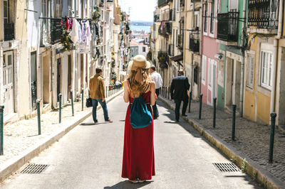 Rear view of woman standing against building