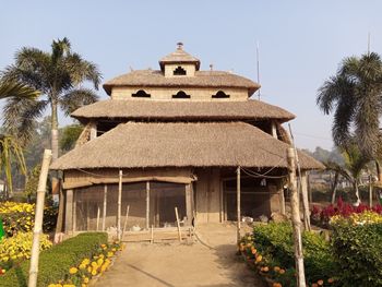 Built structure by trees and building against sky