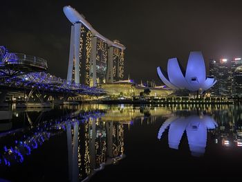 Illuminated bridge over river at night