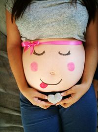 Midsection of pregnant woman with anthropomorphic face