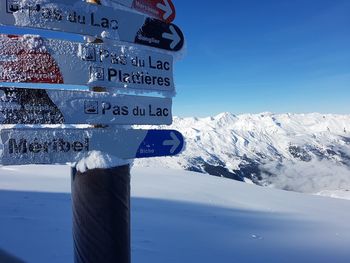 Text on snow covered mountain against blue sky