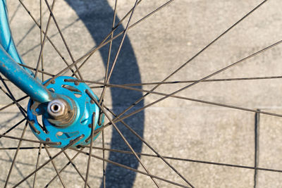 Close-up of blue bicycle front wheel hub and spokes