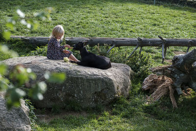 Side view of woman sitting on rock