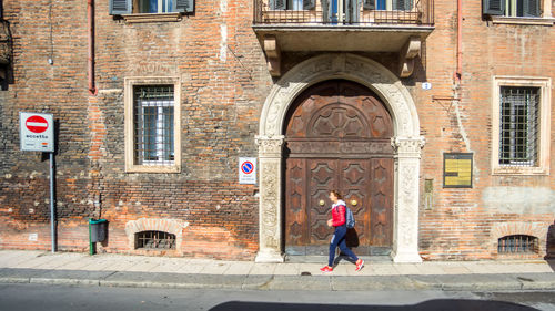 Full length of woman standing against building