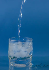 A refreshing glass of water being served. lots of ice, ideal for a summer day.