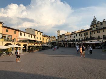 People walking on street against buildings in city