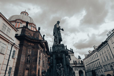 Low angle view of statue of building against cloudy sky