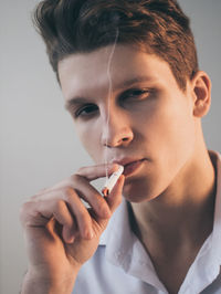 Portrait of young man smoking cigarette