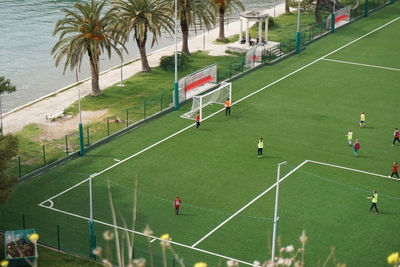 Soccer team practice near a palm beach high angle