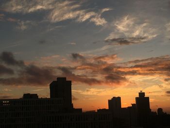 Silhouette buildings against sky during sunset