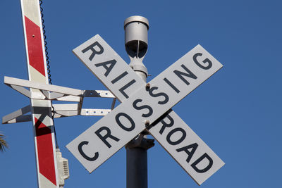 Low angle view of information sign against blue sky