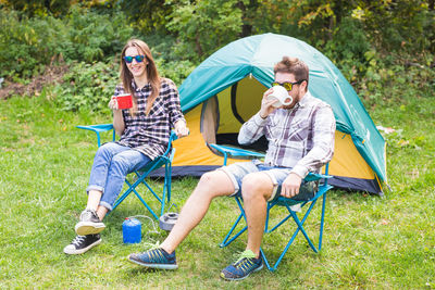 Young couple sitting on tent