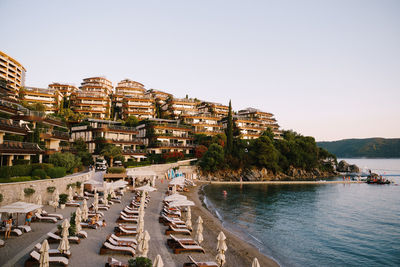 Aerial view of townscape by sea against clear sky