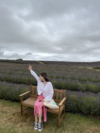 A woman sitting on the bench in the lavender field