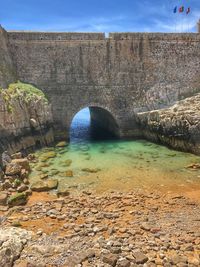 Scenic view of river by cliff against sky