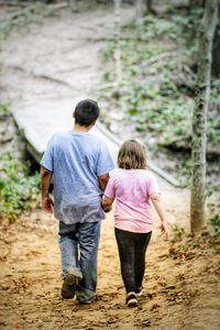 Rear view of kids walking outdoors