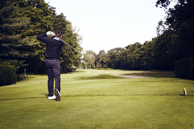 Rear view of man playing golf