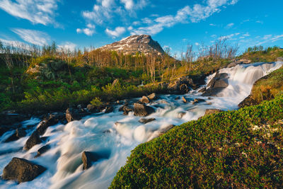 Scenic view of waterfall against sky