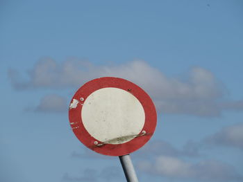 Close-up of road sign against sky