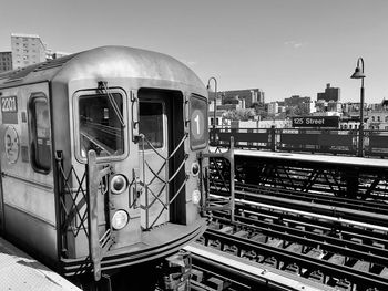 Train on railroad tracks in city against clear sky