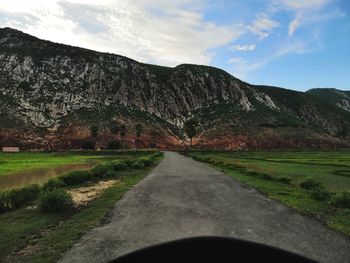 Road by mountain against sky