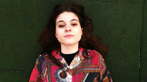 High angle portrait of teenage girl lying on floor