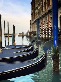 Boats moored in city against sky