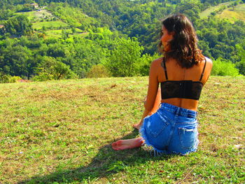 Rear view of woman on grass in field