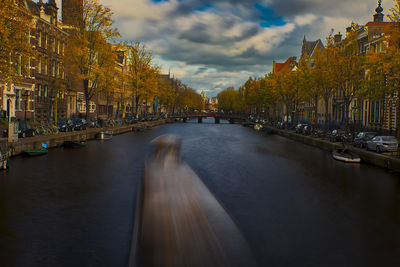 Panoramic view of canal amidst city against sky
