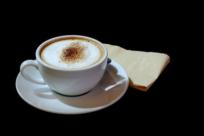 Close-up of coffee cup against black background