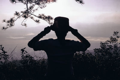 Silhouette woman standing against sky